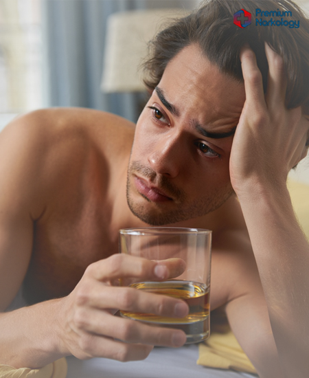 Мужчина с алкоголем в руках в кровати