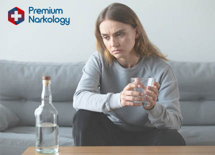 Женщина со стаканом алкоголя на диване