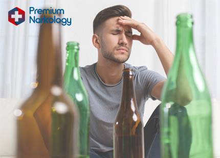 Мужчина сидит рядом с бутылками