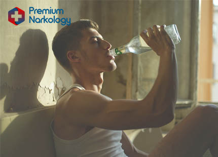 Мужчина пьёт водку из бутылки