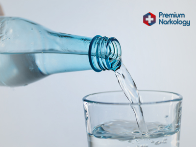 В стакан льётся вода из бутылки