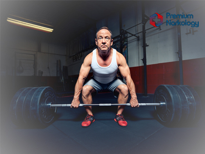 Мужчина пытается поднять гантель